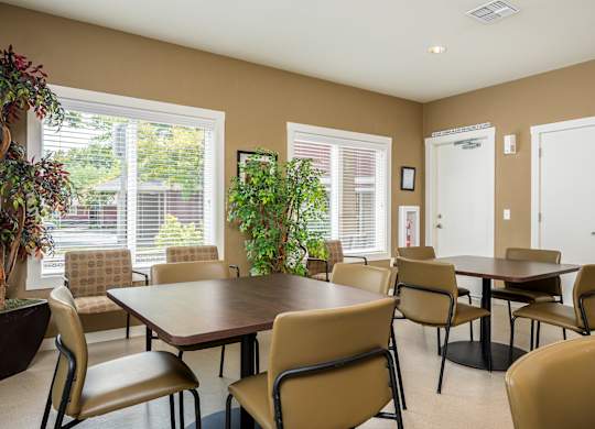 A dining room with a table surrounded by chairs.