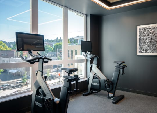 two exercise bikes in a gym next to a window at Slabtown Square Apartments, Portland ,Oregon, 97209