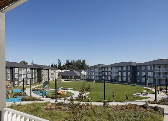 A view of apartment buildings with a pool and playground.
