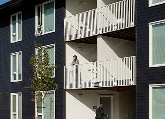A woman is walking her dog on a balcony.