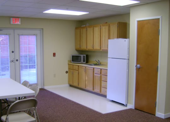 a kitchen with a refrigerator and a table and chairs