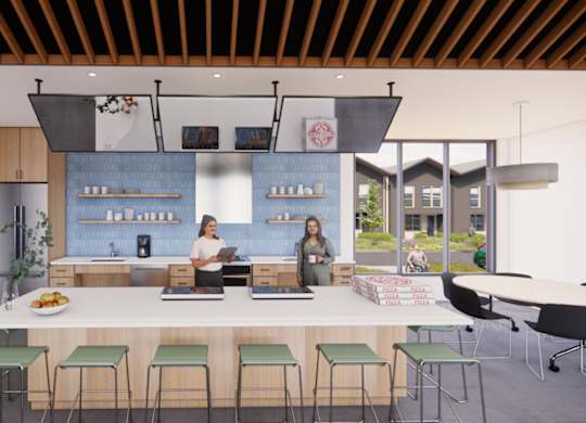 Two people are standing behind a counter in a modern kitchen.