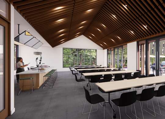 A room with tables and chairs and a person sitting at a table.