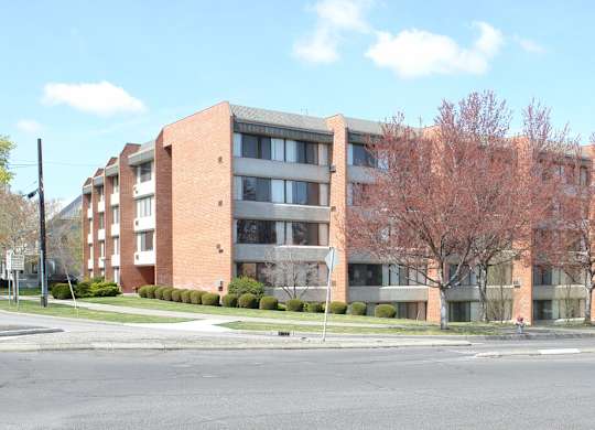 A large brick building with a tree in front of it.