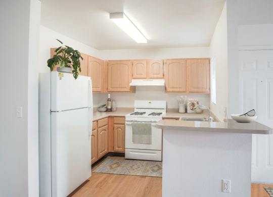 a renovated kitchen with white appliances and wooden cabinets