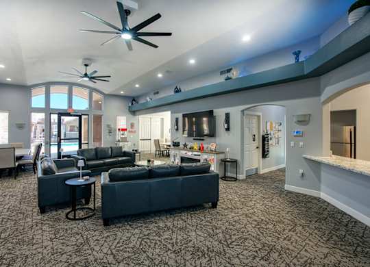 A spacious living room with a grey carpet and furniture.