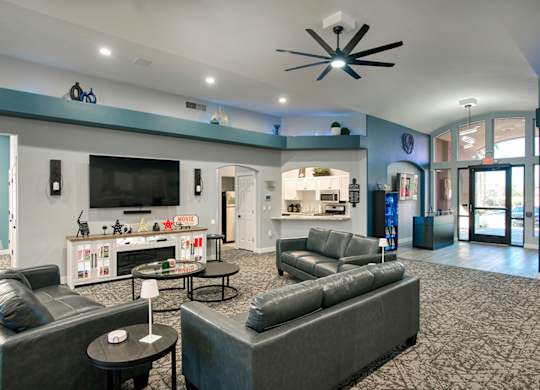 A spacious living room with grey couches and a television.