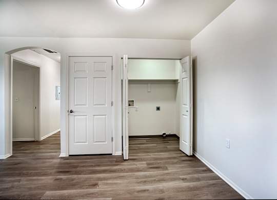 A white door is in a room with wood flooring.