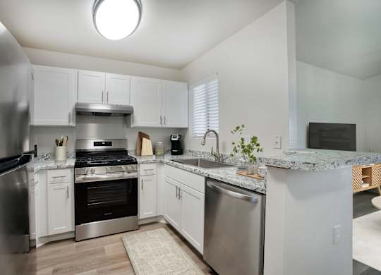 A kitchen with white cabinets and stainless steel appliances.