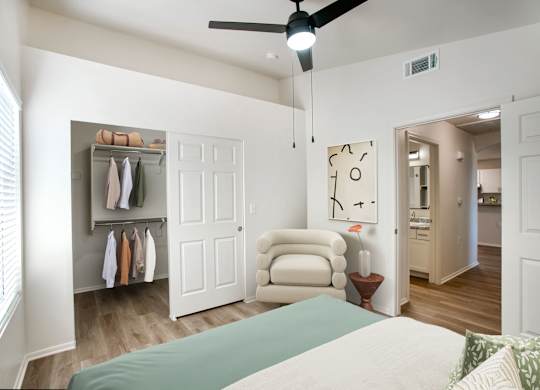 A bedroom with a bed, chair, and closet.