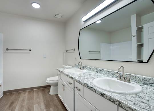 A bathroom with a marble countertop and a large mirror.