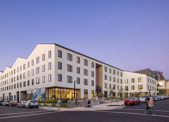 A modern building with a parking lot in front of it.