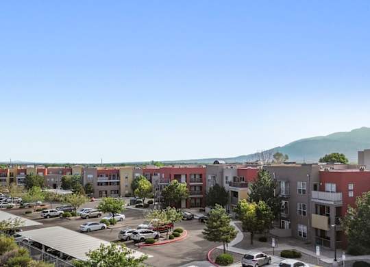 A parking lot is in the foreground of a residential area.