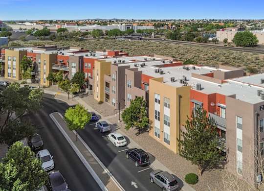 A street view of a residential area with cars and buildings.