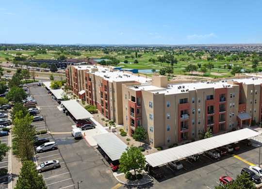 A large apartment complex with a parking lot in front.