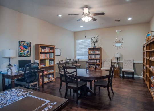 a living room with a dining room table and bookshelves