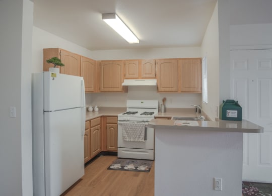 a kitchen with white appliances and wooden cabinets