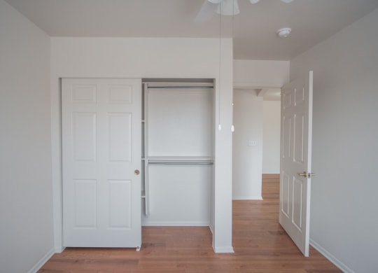 an empty hallway with white doors and a closet