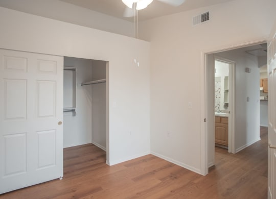 an empty living room with white walls and a wood floor