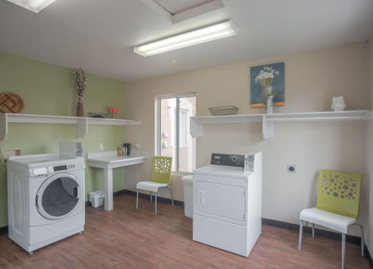 a laundry room with two washing machines and a table with chairs