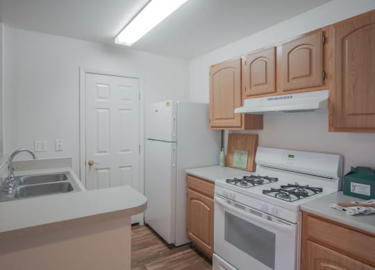 a kitchen with white appliances and wooden cabinets