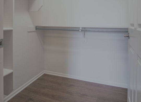 an empty room with a white wall and a wood floor