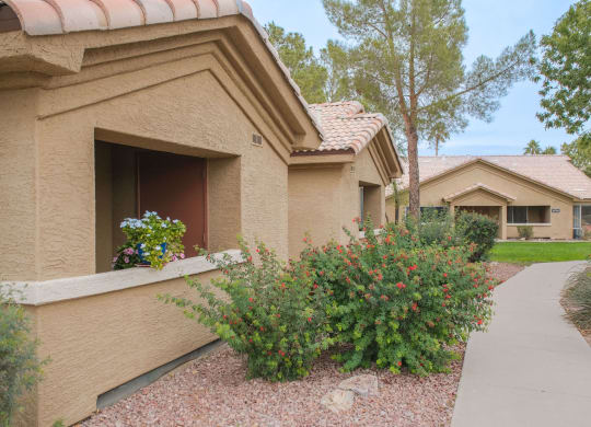 a house with a sidewalk in front of it and some flowers
