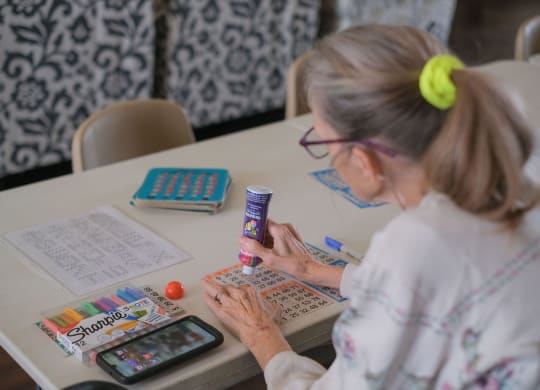 a woman sitting at a table using a calculator on a calculator