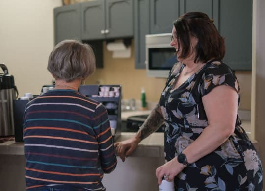 two women in a kitchen talking to each other