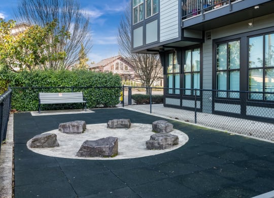 a park with a bench and rocks in front of a building