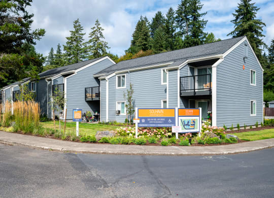 a blue house with a sign in front of it