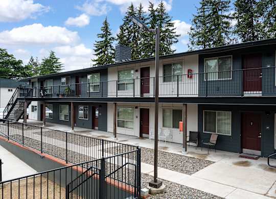 A row of modern townhouses with balconies and black railings.