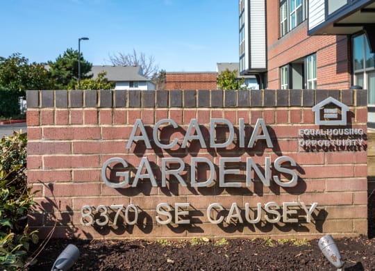 a sign for acadia gardens in front of a building