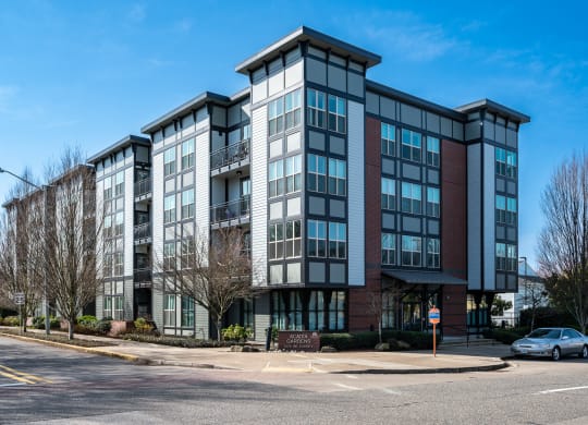 an apartment building on a street corner with a blue sky in the background