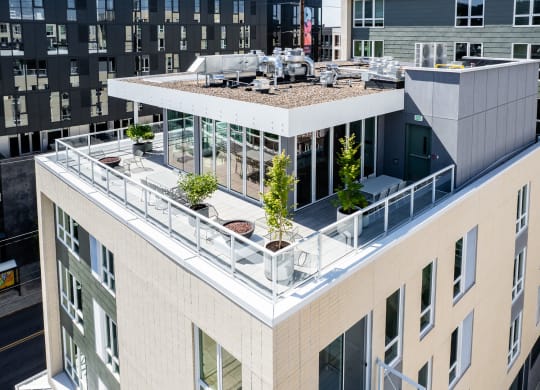 an aerial view of a large building with a rooftop terrace and plants at Slabtown Square Apartments, Oregon