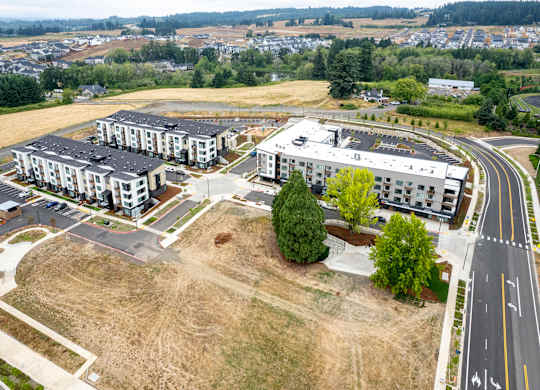A large open field with apartment buildings in the distance.