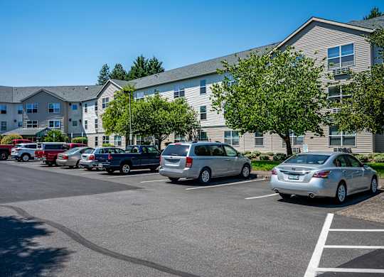 A parking lot with cars and a building in the background.