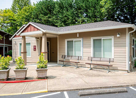 A small building with a red fire alarm on the wall.