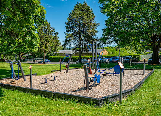 A playground with a seesaw, swings, and a slide.