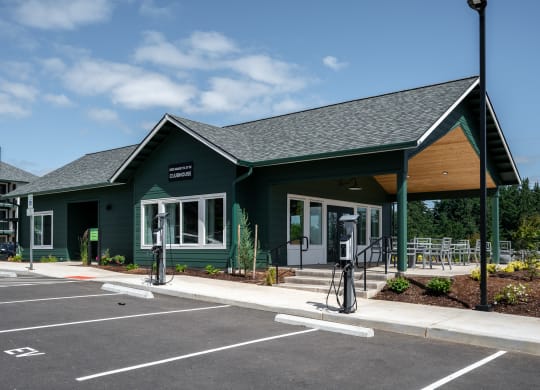 a green building with a porch and a parking lot
