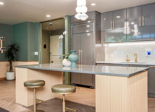 A modern kitchen with a bar stool and a counter.