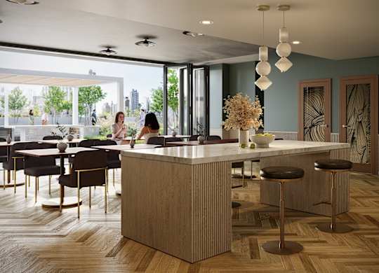 A woman is sitting at a table in a modern kitchen.