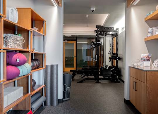A room with a gym equipment set up and a shelf with various items.