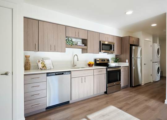 A modern kitchen with wooden cabinets and stainless steel appliances.