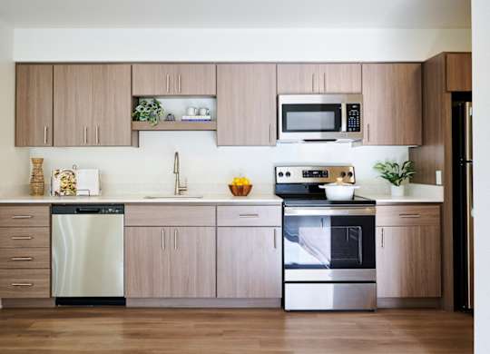 A modern kitchen with wooden cabinets and stainless steel appliances.