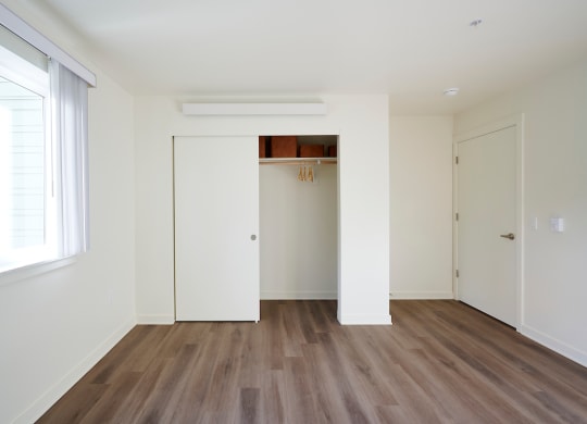 an empty living room with white walls and wood floors
