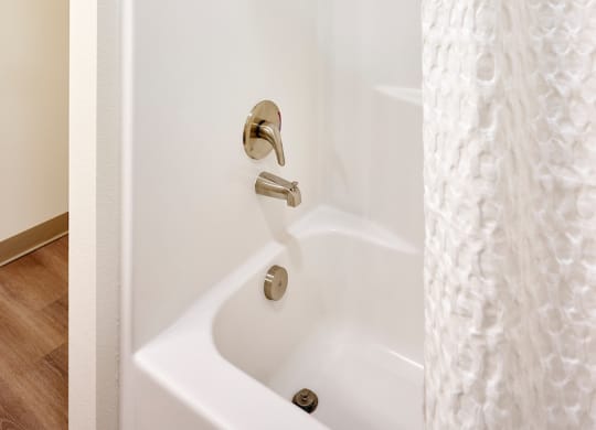 a white shower in a bathroom with a shower curtain