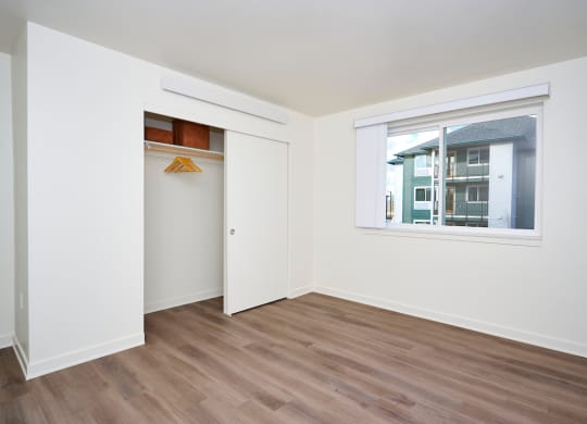 a bedroom with a window and a door to a closet