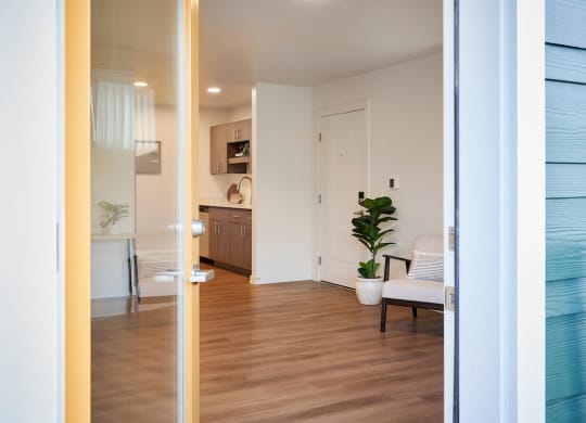 a view of a living room and a kitchen from a door