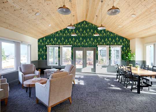 A room with a green wallpaper and wooden ceiling.